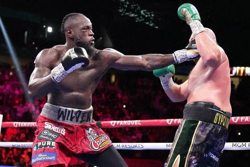 Deontay Wilder punches Tyson Fury in their heavyweight trilogy fight